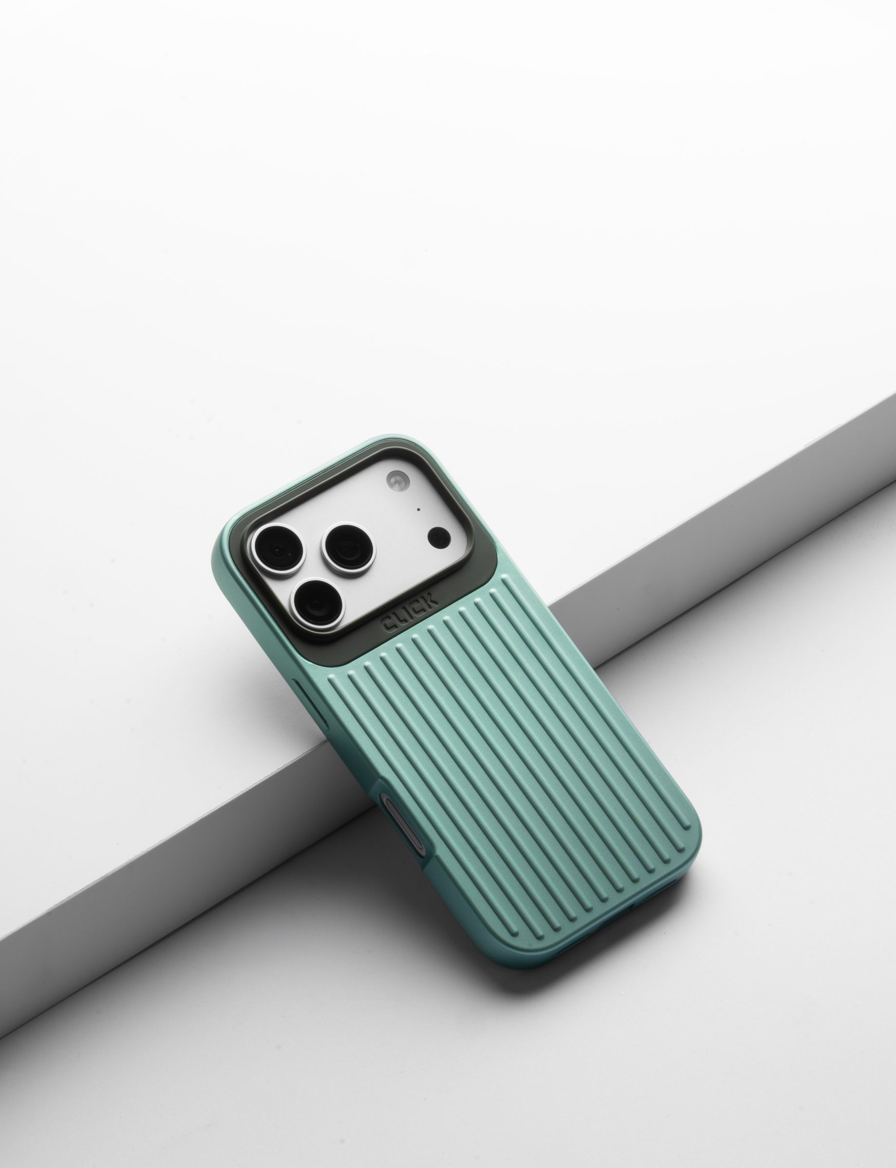 Mint CLICK Nova case on a phone, leaning on a gray ledge against a white backdrop